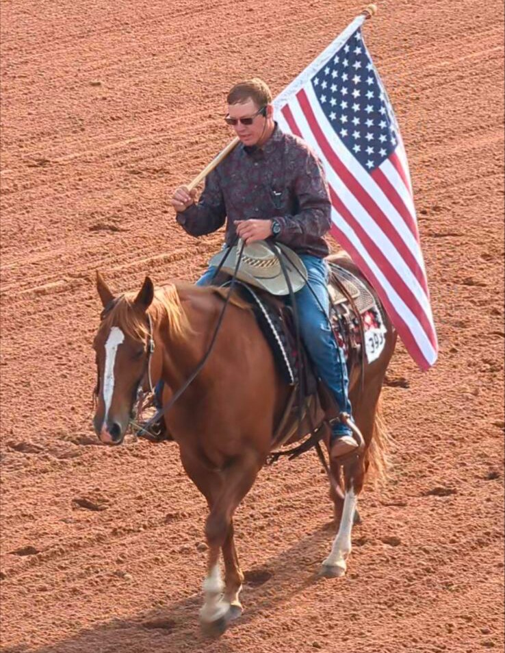 Jon Dorau carrying the American flag on horseback